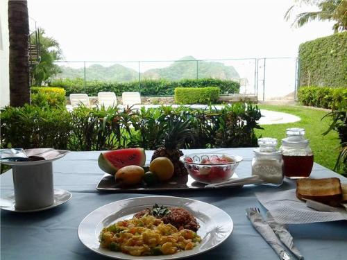 a table topped with plates of food and drinks at HC Liri Hotel in San Juan del Sur