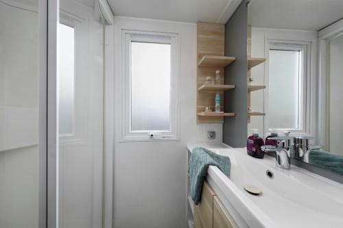 une salle de bain avec un lavabo et une fenêtre dans l'établissement KNAUS Campingpark Eckwarderhörne, à Eckwarderhörne
