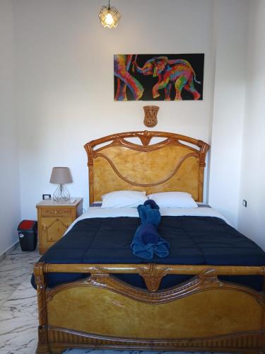 a bed with a blue teddy bear sitting on it at Villa Mena Luxor in Luxor