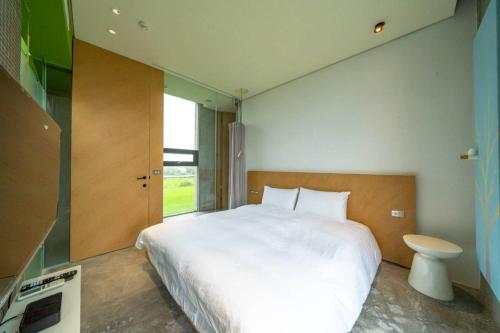 ein Schlafzimmer mit einem großen weißen Bett und einem Fenster in der Unterkunft 懶懶小日子 in Hou-hou