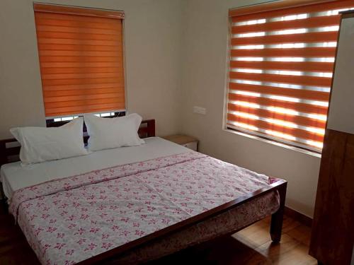 1 Schlafzimmer mit einem Bett und 2 Fenster mit Jalousien in der Unterkunft Hilton Hill in Varkala