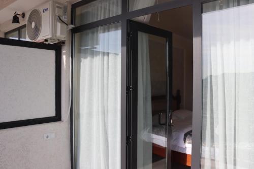 a sliding glass door with a window in a room at Hotel Kochana in Chʼkhorotsqu