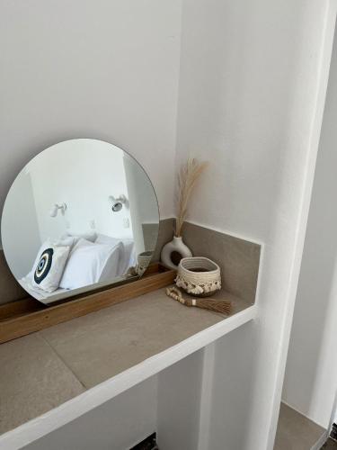 a bathroom with a mirror on a shelf at Vivazoi Ousia studio # 3 in Leipsoi