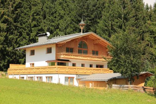 een groot houten gebouw op een heuvel met bomen bij Chalet Findeisen in Ramsau am Dachstein