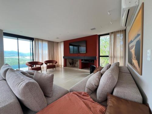 un soggiorno con un divano e una televisione di Casa Céu do Siriú a Garopaba