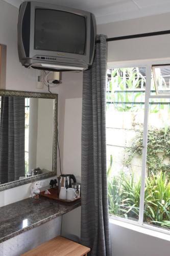 een televisie die boven een raam in een keuken hangt bij Siesta B&B in Vryheid