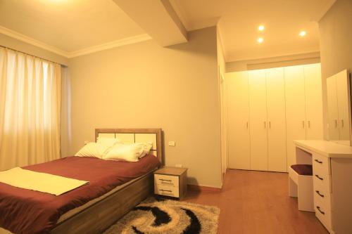 a bedroom with a bed and a dresser and a closet at Joy Apartment in Addis Ababa