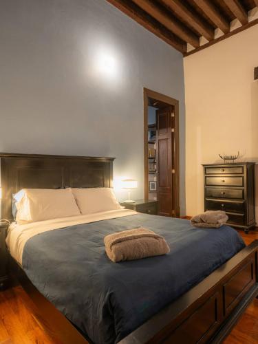 a bedroom with a large bed with two towels on it at Casa colonial en el corazón del Centro Histórico in Mexico City