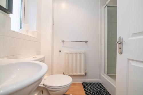 ein weißes Badezimmer mit Toilette und Waschbecken in der Unterkunft 5 bed house with free secure parking in pleasant quiet location in Wolverhampton
