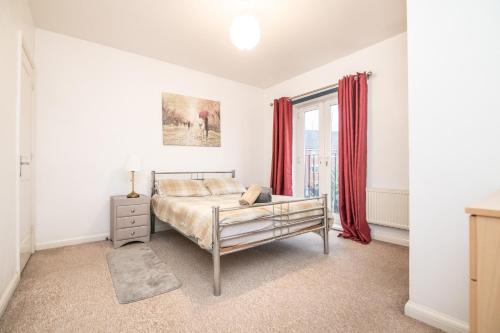 ein Schlafzimmer mit einem Bett und einem Fenster mit roten Vorhängen in der Unterkunft 5 bed house with free secure parking in pleasant quiet location in Wolverhampton