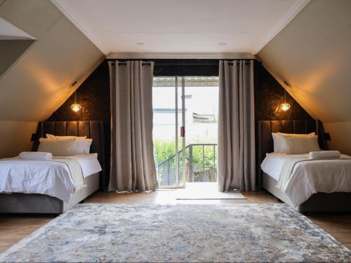 een slaapkamer met twee bedden en een groot raam bij Fossil Lane in Clarens