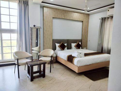 a bedroom with a bed and a table and chairs at Hotel Casa Del Sol in Raipur