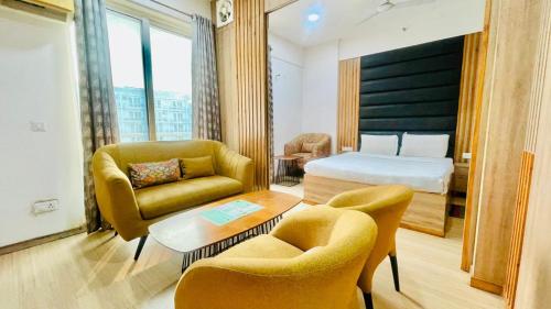 a hotel room with a bed and a table and chairs at Hotel The Grace Residency - Near Hotel Hyatt ,DLF MyPad, Gomtinagar, Lucknow in Lucknow