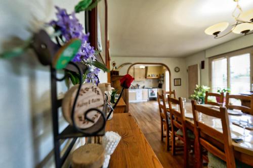 une salle à manger avec une table avec des fleurs violettes dessus dans l'établissement TY Lavarion, au Bono