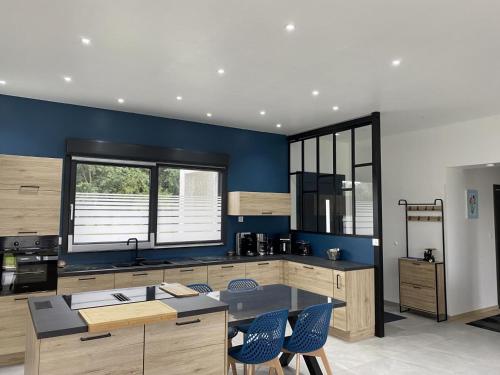 eine Küche mit blauen Wänden sowie einem Tisch und Stühlen in der Unterkunft Gite de l'etoile in Rocroi