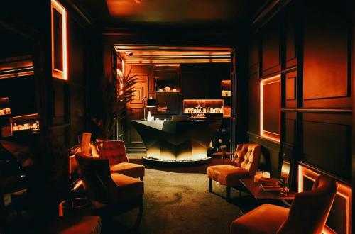 a room with a bar with a fireplace and chairs at Impossible Motel in York
