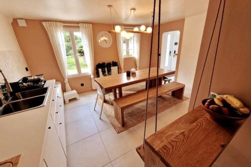 een keuken met een tafel en een schommel bij Les Jardins de Rosie in Arthies