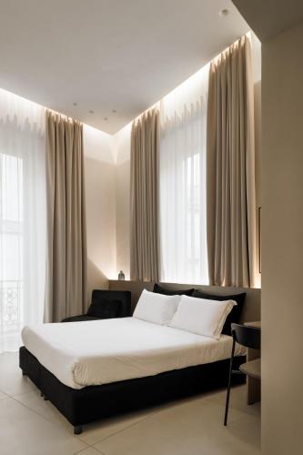 a bedroom with a large bed in front of windows at Iodis Relais in Naples