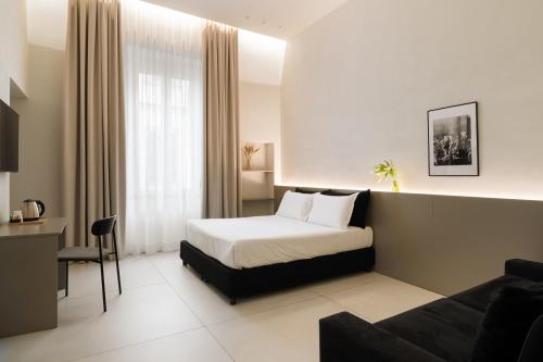 une chambre d'hôtel avec un lit et un canapé dans l'établissement Iodis Relais, à Naples
