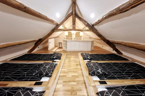 een kamer met 3 bedden op een zolder bij Les Jardins de Rosie in Arthies