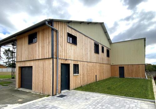 un grande edificio in legno con un prato di Gîte 535 a Saulces-Monclin