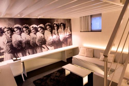 a living room with a painting of women on the wall at Hotel Harmony in Ghent