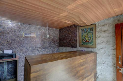 una stanza con soffitto in legno e pareti in pietra di Hotel O Gold Inn a Faridabad