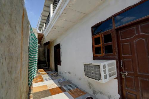 un corridoio vuoto con una porta e una finestra di Hotel O Gold Inn a Faridabad