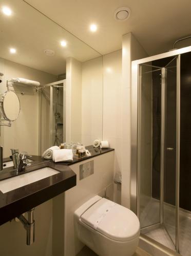 a bathroom with a toilet and a sink and a shower at TURIM Av. Liberdade Hotel in Lisbon