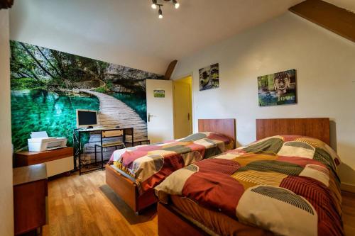 two beds in a room with a painting on the wall at TY Lavarion in Le Bono