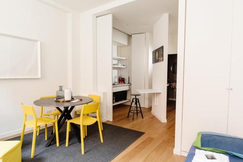 une salle à manger avec une table et des chaises jaunes dans l'établissement 009 - Corso Palestro - Historic Center Design Flat, à Brescia