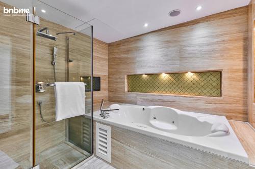 a bathroom with a tub and a glass shower at bnbmehomes - Al Badia Hillside Village Condo 3 in Dubai