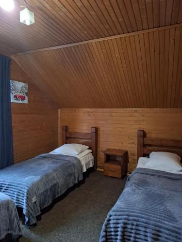 a bedroom with two beds and a wooden ceiling at Вежа in Bukovel