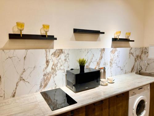 a kitchen with a counter with a microwave and wine glasses at ЖК Абая 5 in Kokshetau