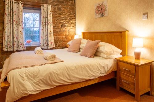 En eller flere senge i et værelse på Highcroft at Wetheral Cottages
