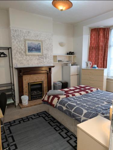 a bedroom with a bed and a fireplace at Kettering 4 night min stay with Shared Bathroom, lounge TV & kitchen free WIFI Genius on longer regular stays Professional workers Rooms in Kettering