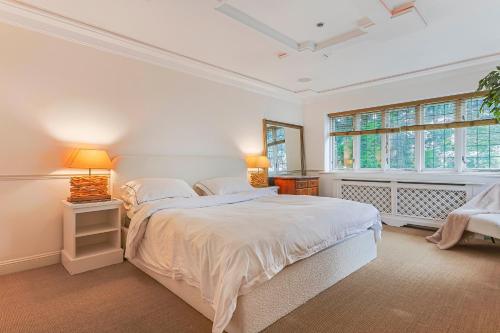 a white bedroom with a large bed and two lamps at Sobo House in Southbourne