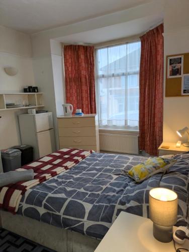 a bedroom with a bed and a large window at Kettering 4 night min stay with Shared Bathroom, lounge TV & kitchen free WIFI Genius on longer regular stays Professional workers Rooms in Kettering