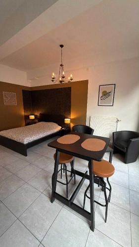 ein Zimmer mit einem Tisch und Stühlen und einem Bett in der Unterkunft Studio center of Mons in Mons