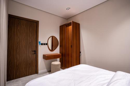 Schlafzimmer mit einem Bett, einem Spiegel und einem Schrank in der Unterkunft our residence in Riad