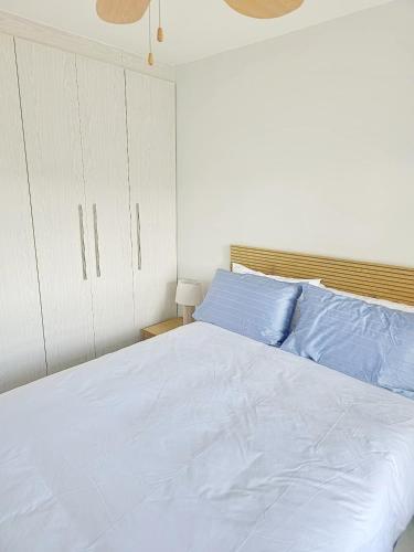 a bedroom with a large white bed with blue pillows at Laguna Grove 20 in Knysna