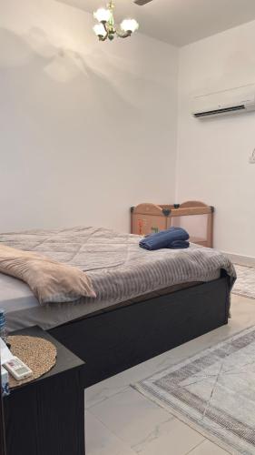 a large bed in a room with a table at Qantab village apartment in Muscat