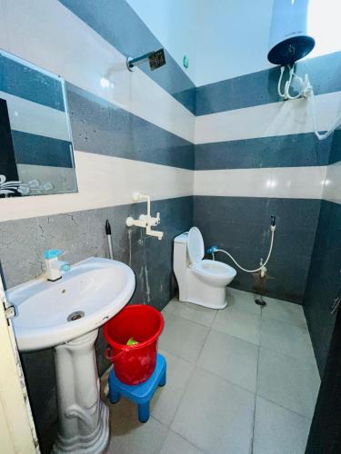 a blue and white bathroom with a sink and a toilet at Shri mohan dham dormitory in Vrindāvan