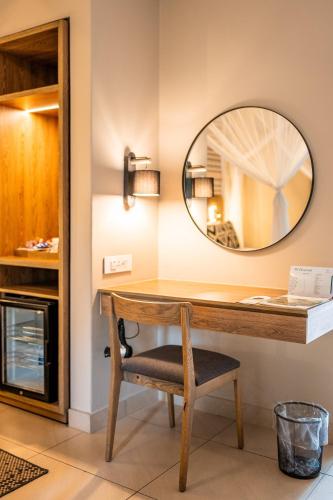 a mirror on a wall next to a desk with a chair at Cresta Sprayview Victoria Falls in Victoria Falls