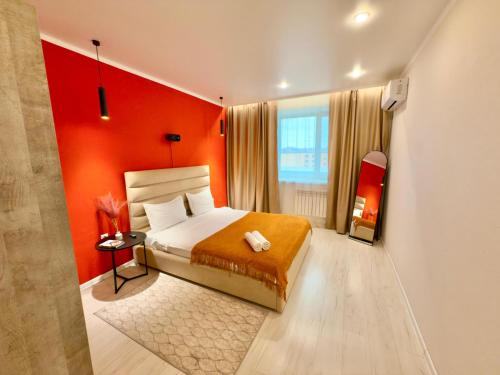 a bedroom with orange walls and a bed in a room at ЖК Абая 5 in Kokshetau