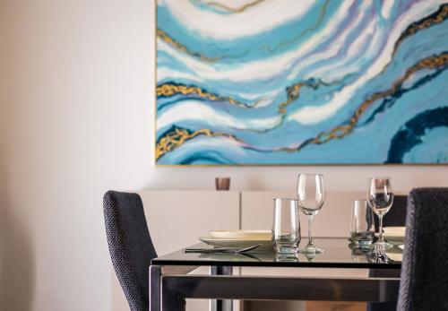 a dining room table with chairs and a painting on the wall at Luxury Apartments with Pool and Terrace, Top Location in Sliema