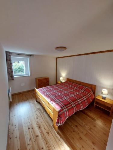 een slaapkamer met een bed met een geruite deken bij Lo Reinard in Nus