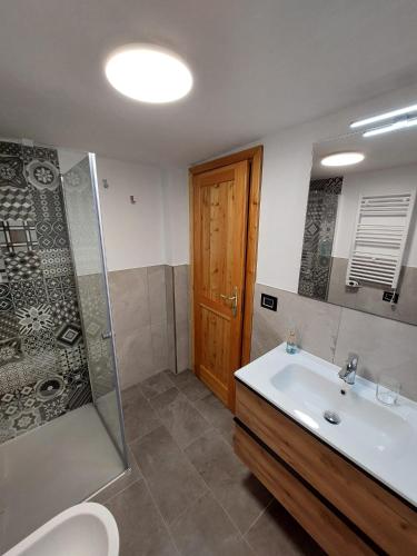 een badkamer met wastafel, douche en toilet bij Lo Reinard in Nus