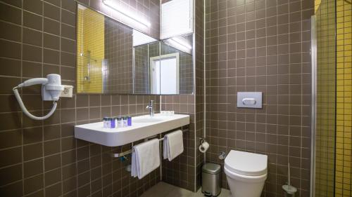 y baño con lavabo, aseo y espejo. en Otel Kefalos, en Gokceada Town