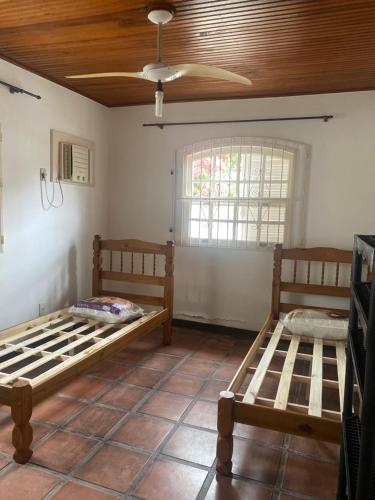 2 Betten in einem Zimmer mit einer Decke in der Unterkunft Almeida dos camaroes in Cabo Frio